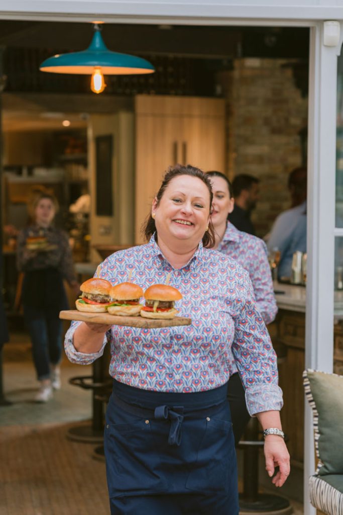 0067 - 2022 - Gees Restaurant & Bar - Oxford - High Res - Andrea Waitressing Burgers - Web Feature