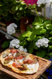 A7R07810 - 2023 - Gees Restaurant & Bar - Oxford - High Res - Artichoke Fig Prosciutto Pizzetta Sunlight Green Flowers - Web Feature
